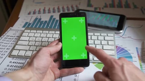 Man Using Smartphone With Green Screen on Workspace