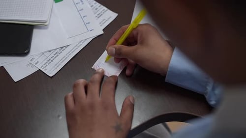 Man Writes Weekly Plan at Desk