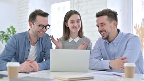 Three Smiling Colleagues Video Conferencing on Laptop