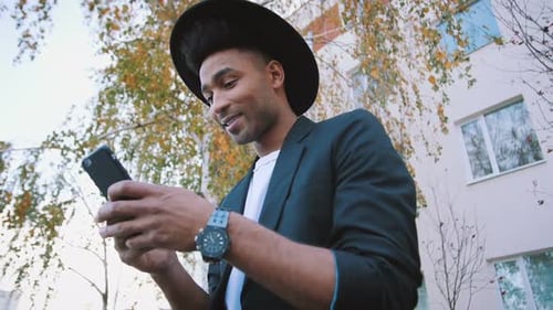 Stylish Man Smiling While Using Mobile Phone