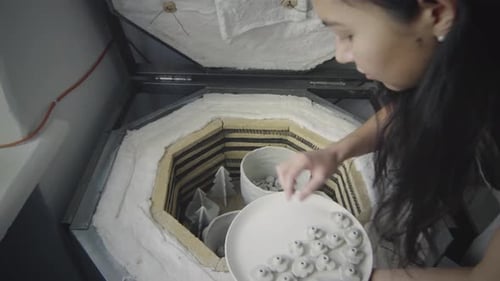 Potter met des objets en argile dans un four à poterie