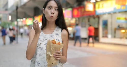Woman eating Hong Kong famous snack, egg puff