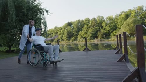 Medic and Elderly Man Look at Fascinating Surrounding of the Park