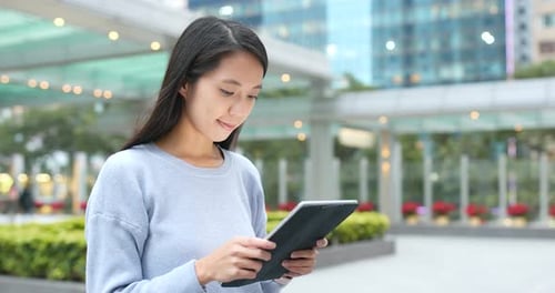 Frau nutzt digitalen Tablet-Computer im Freien