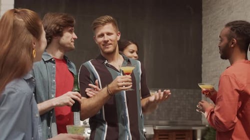 Five Multiethnic Friends Chatting and Drinking Cocktails on Terrace