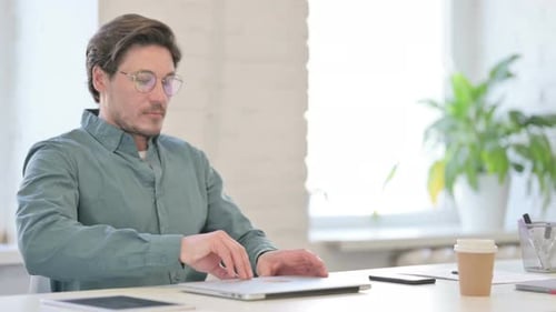 Man Working at Laptop in Bright Office