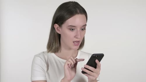 Woman Reacting to Smartphone with Surprise and Sadness