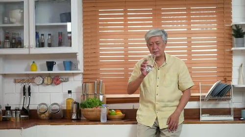 Senior Man Drinking Water in Bright Kitchen