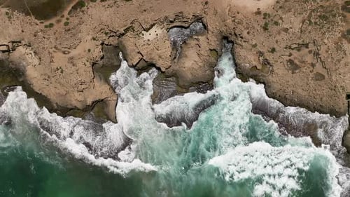 Stormy sea with waves breaking, white foam and beach sand dragged into the sea - Winter weather at s