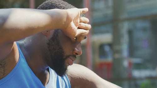 Aframerican Athlete Wiping Sweat From His Forehead After Grueling Workout