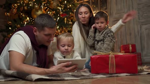 Family Using Tablet near Christmas Tree
