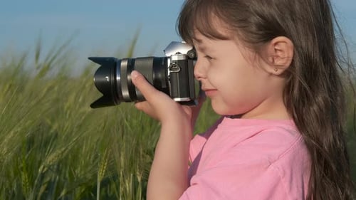 Young Child Taking Photos in Green Field