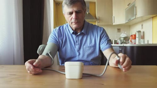 Adult Male Takes Blood Pressure in Home