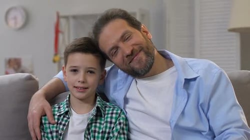 Man and Boy Sit Together Affectionately