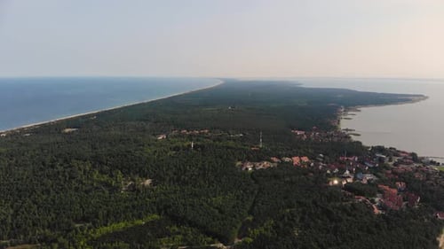 AERIAL: flying backwards and revealing little fisherman village near the sea shore on the edge of th