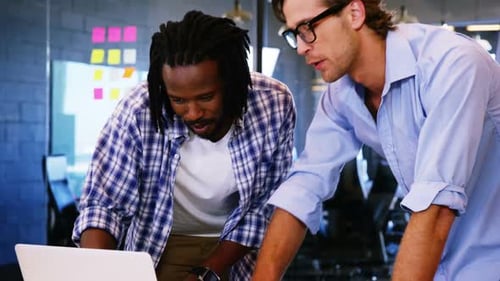 Colleagues Collaborating on Laptop in Modern Office