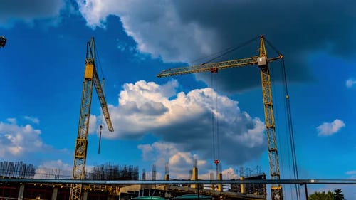 Three Yellow Construction Cranes Work on Site of a Building Under Construction Time Lapse