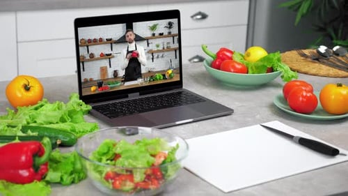 Ordenador portátil con un chef, un bloguero gastronómico en la pantalla, enseña a los estudiantes
