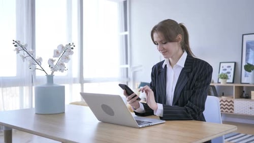 Woman Using Smartphone in Bright Modern Workspace