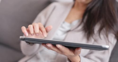 Fingers scrolling on tablet indoors