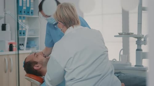 Medical Professionals Giving Dental Care to Patient