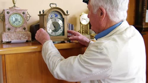 Gray Haired Man Working on Clocks