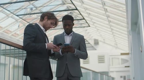 Businessmen Talking, Using Smartphones in Modern Office
