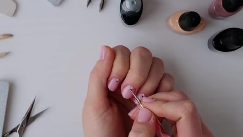 Woman Applies Polka Dots to Pink Manicure