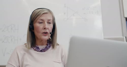 Close Up View of Beautiful Female Professor in Wireless Headset with Mic Talking While Looking at