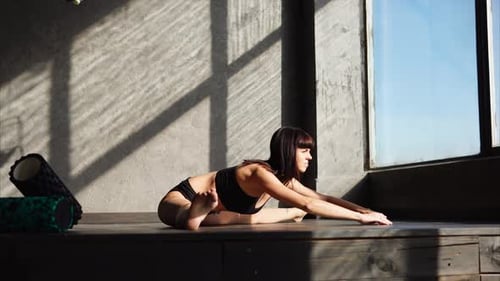 Young Woman Doing Yoga and Stretching Indoors