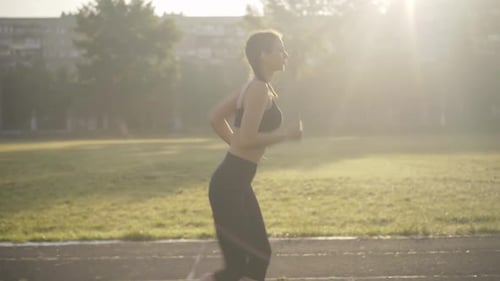 Slim Caucasian Woman Launching App on Smart Watch and Start Running. Side View Portrait of Confident