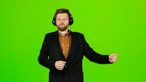 Guy Listens To Energetic Music in Headphones and Dances. Green Screen