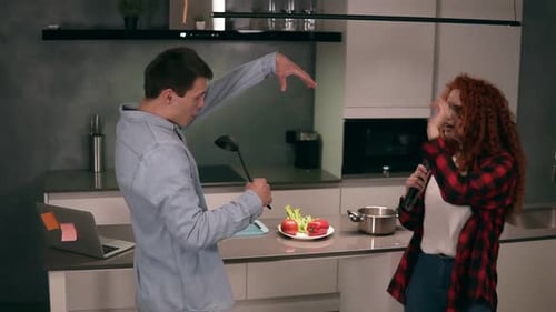 Couple Singing and Dancing Together in Kitchen
