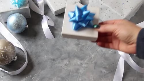 Hand Places Birthday Gift with Blue Bow