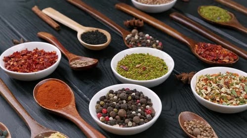 Dry Colorful Spices in Spoons and Bowls with Fresh Seasoning on Dark Background Top View