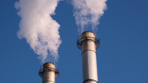 Smokestacks Venting White Plumes Against Blue Sky