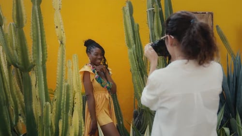 Woman Photographer Shoots Smiling Woman by Cacti Wall