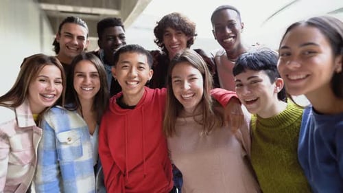 Happy multiracial group of teenagers having fun smiling on camera inside university