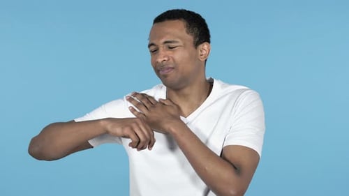 Young Adult Massaging Sore Shoulder in Studio