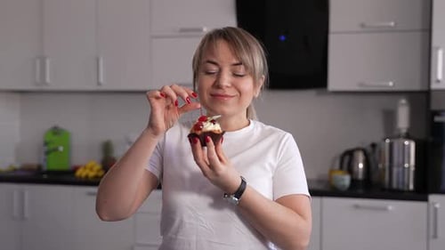 Woman Eats Cherry Cupcake in Bright Kitchen
