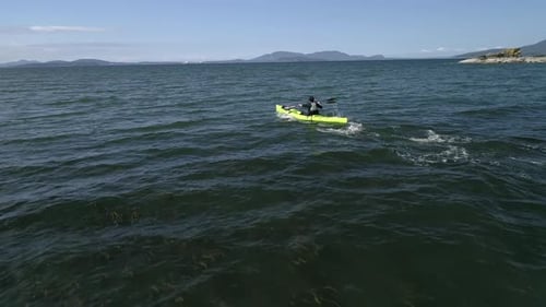 Drone Flying Low By Man Paddling Fast In Ocean Kayak
