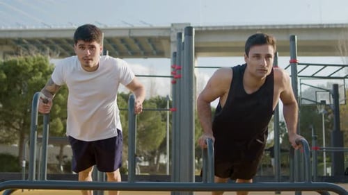 Young Men Exercising on Parallel Bars Outdoors