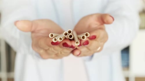Cero desperdicio. Mujer sosteniendo una pajita ecológica de bambú de papel en descomposición.