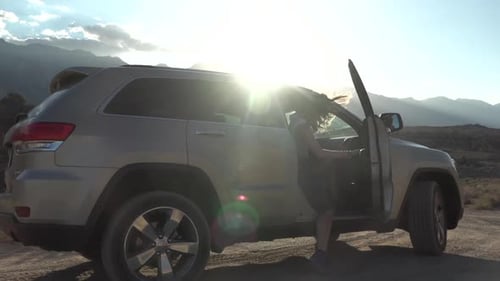Woman Getting into SUV on Desert Road