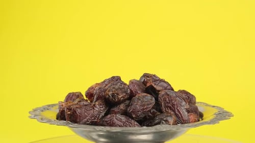 Pile of Dates Rotate on Silver Bowl
