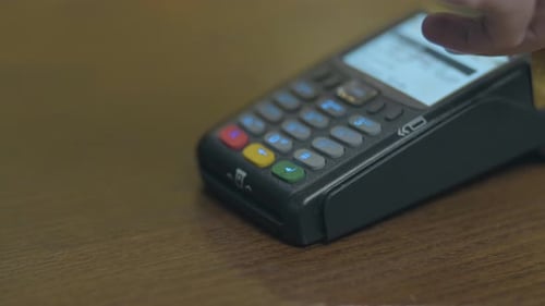 Hand Enters Pin on Credit Card Reader