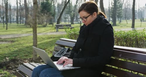 Woman working on laptop in the park