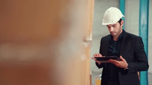 Factory Manager Using Tablet Computer in Warehouse or Factory