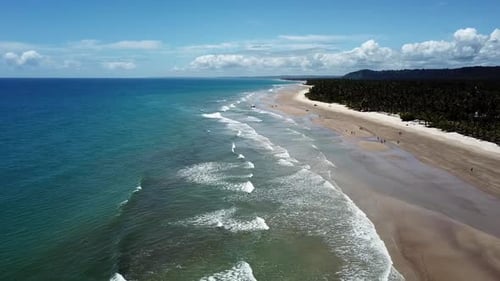 Waves crashing against the sandy beach in this tropical paradise - aerial view