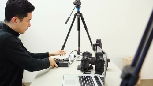 Young Adult Adjusting Photography Equipment in Studio